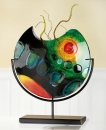 GlasArt Vase auf Ständer "Sunrise" Vase aus Fusingglas: blau, rot, grün, orange Ständer aus Metall, schwarz lackiert Hinterwandmalerei L= 5,0 cm B= 31,0 cm H= 37,0 cm